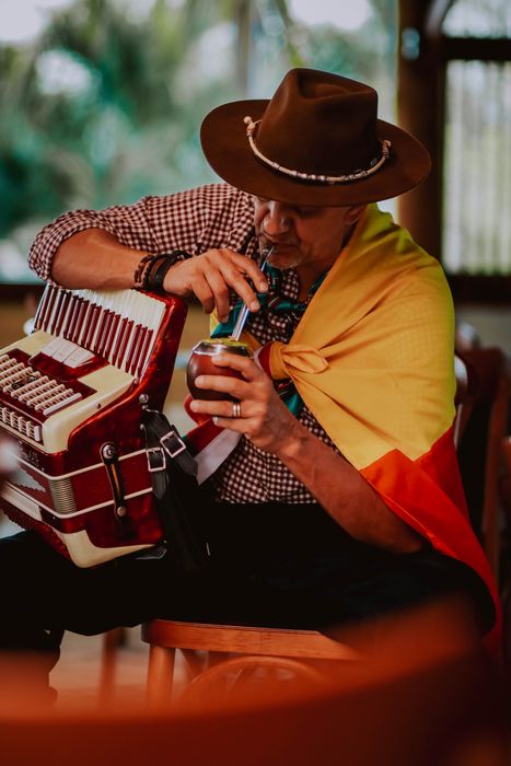 Carlos Magrão tomando chimarrão ao lado da gaita