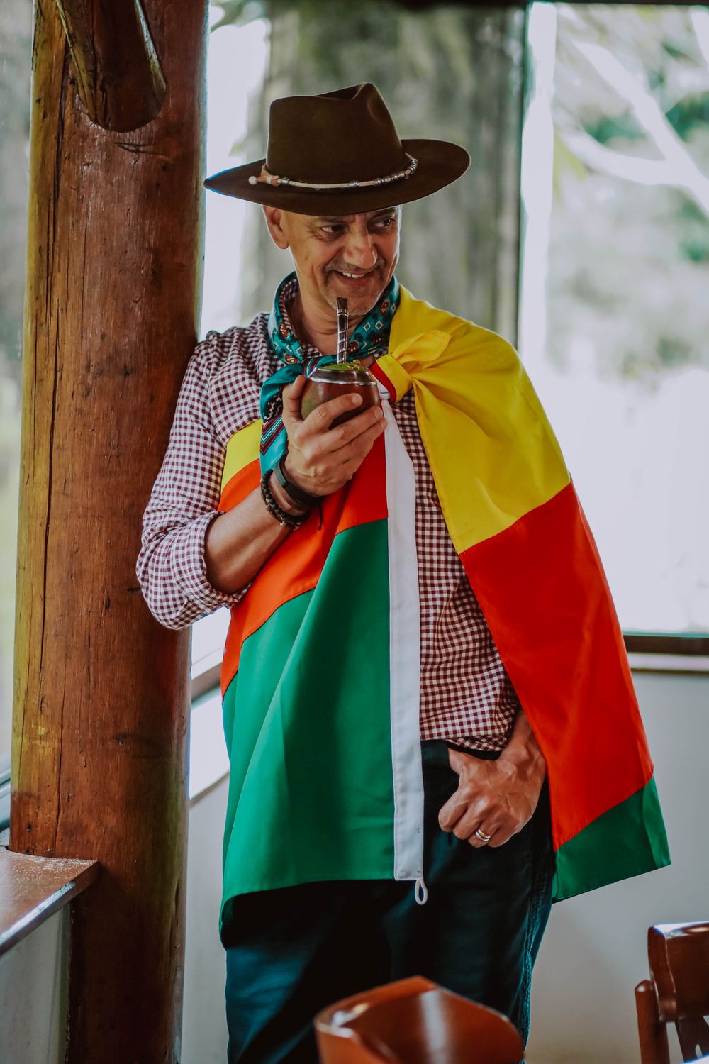 Carlos Magrão com a bandeira do Rio Grande do Sul nos ombros, tomando chimarrão
